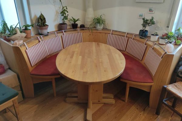 Runde Eckbank mit Tisch und zwei Stühlen