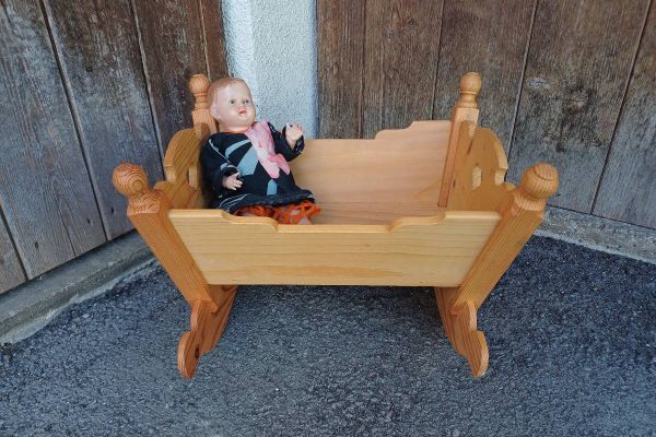Kleine Puppenwiege mit alter Puppe