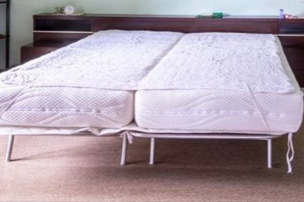 Zwei Bettgestelle mit Matratzen.